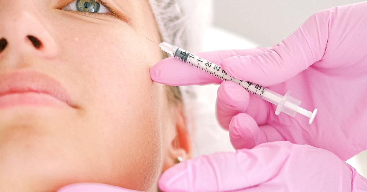 Close-up of a beautician administering facial injection treatment to a woman in a clinical setting.